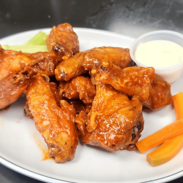 Shorty's American cuisine features a plate of buffalo wings with celery, carrots, and dipping sauce.