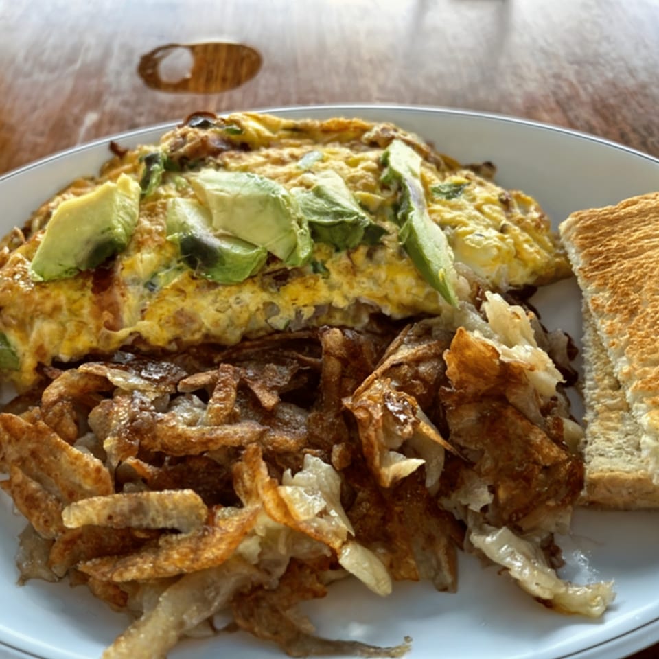 Shorty's American breakfast with an avocado omelet, crispy hash browns, and white toast.
